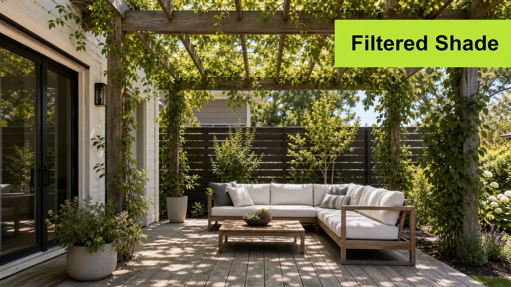 A modern wooden pergola provides filtered shade over a comfortable outdoor patio seating area with a sofa.