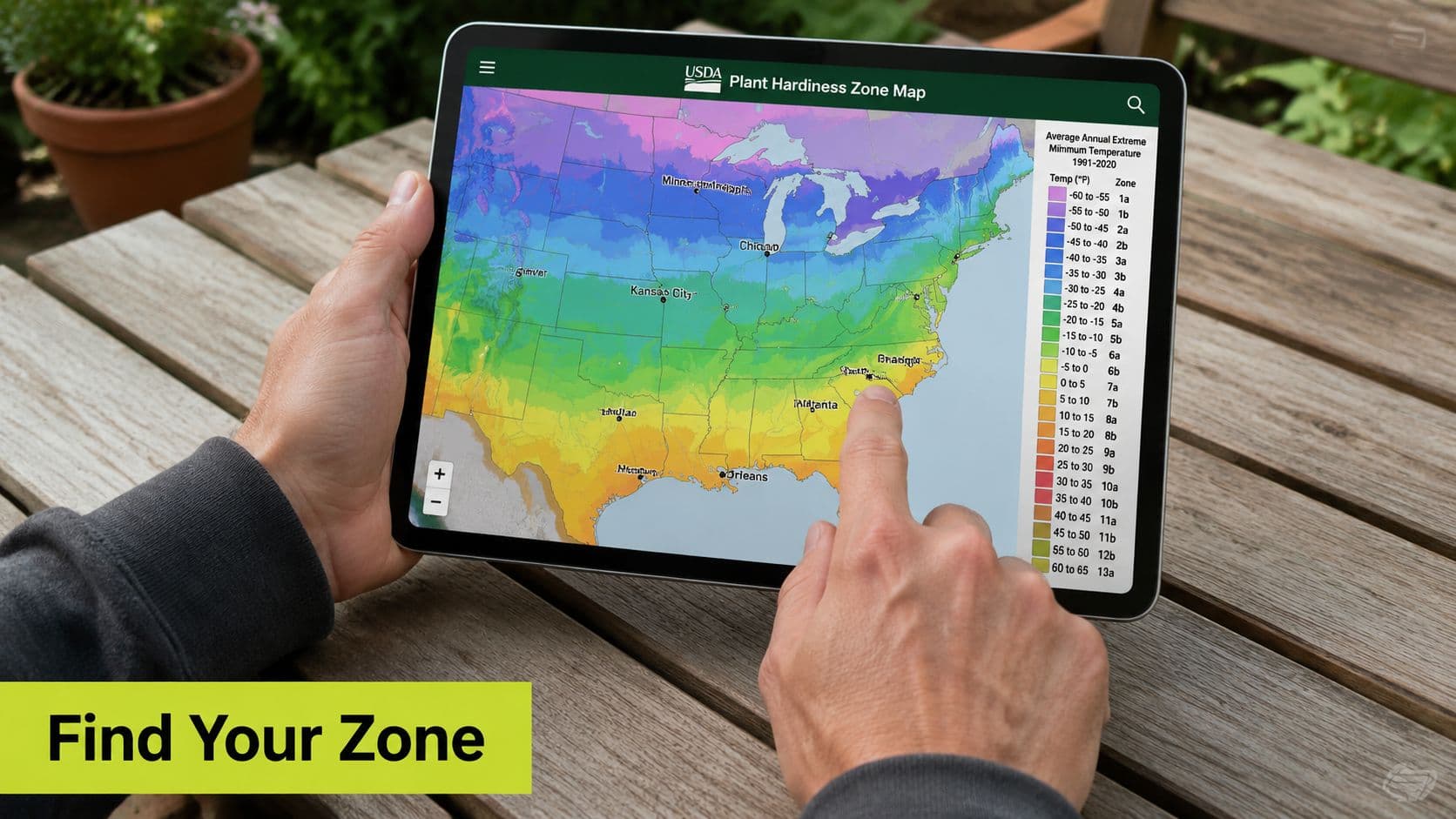 A person using a digital tablet to view a USDA Plant Hardiness Zone Map for gardening.